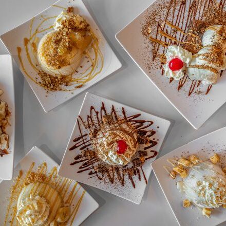 Assorted gourmet ice cream sundaes with toppings and sauces.